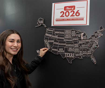 student point to a map on the wall showing where she matched