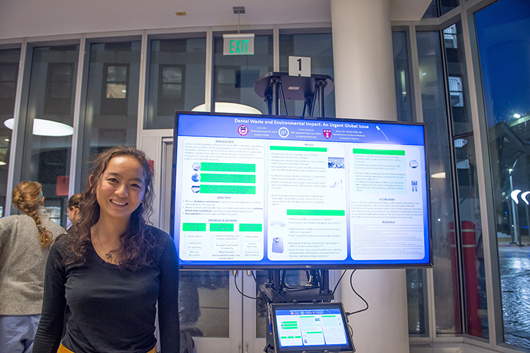 Jenna Mu, a student at Boston College, presents the team's research on dental waste at a poster session