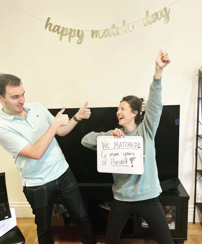 Two people celebrating, holding sign that reads 