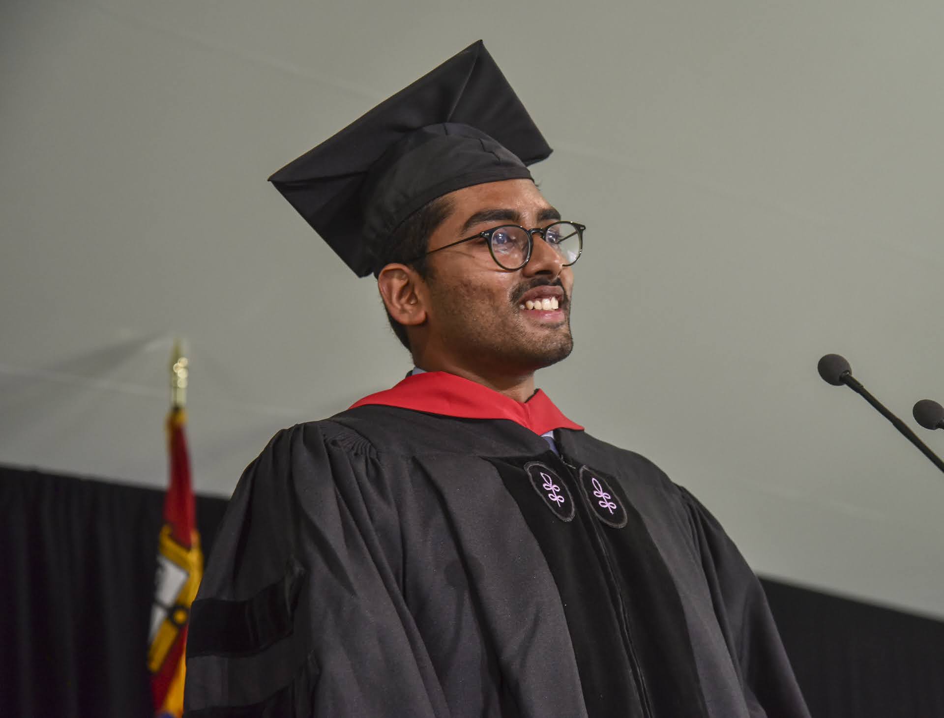 Student standing on stage behind podium speaking