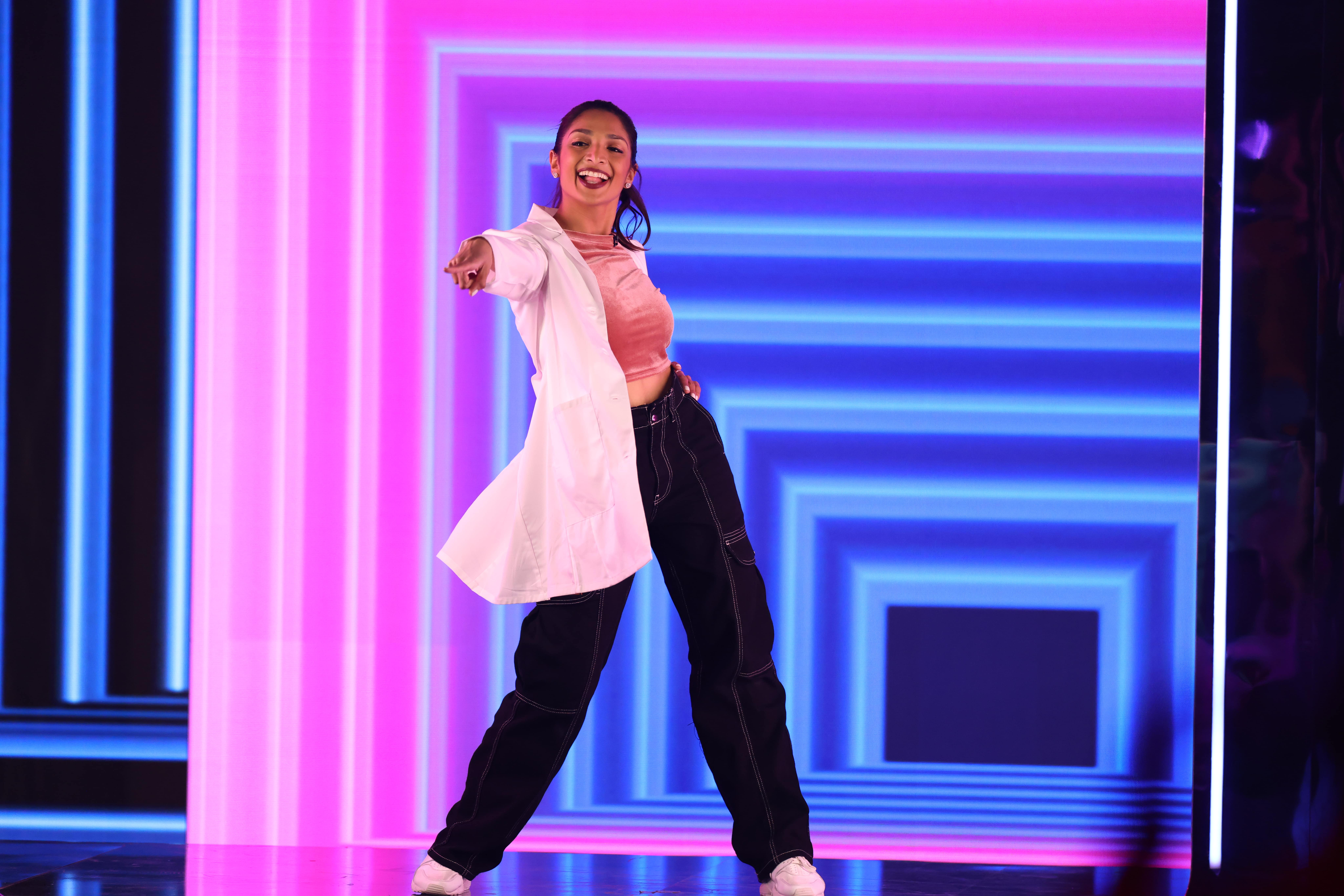 Person standing on a brightly lit stage pointing