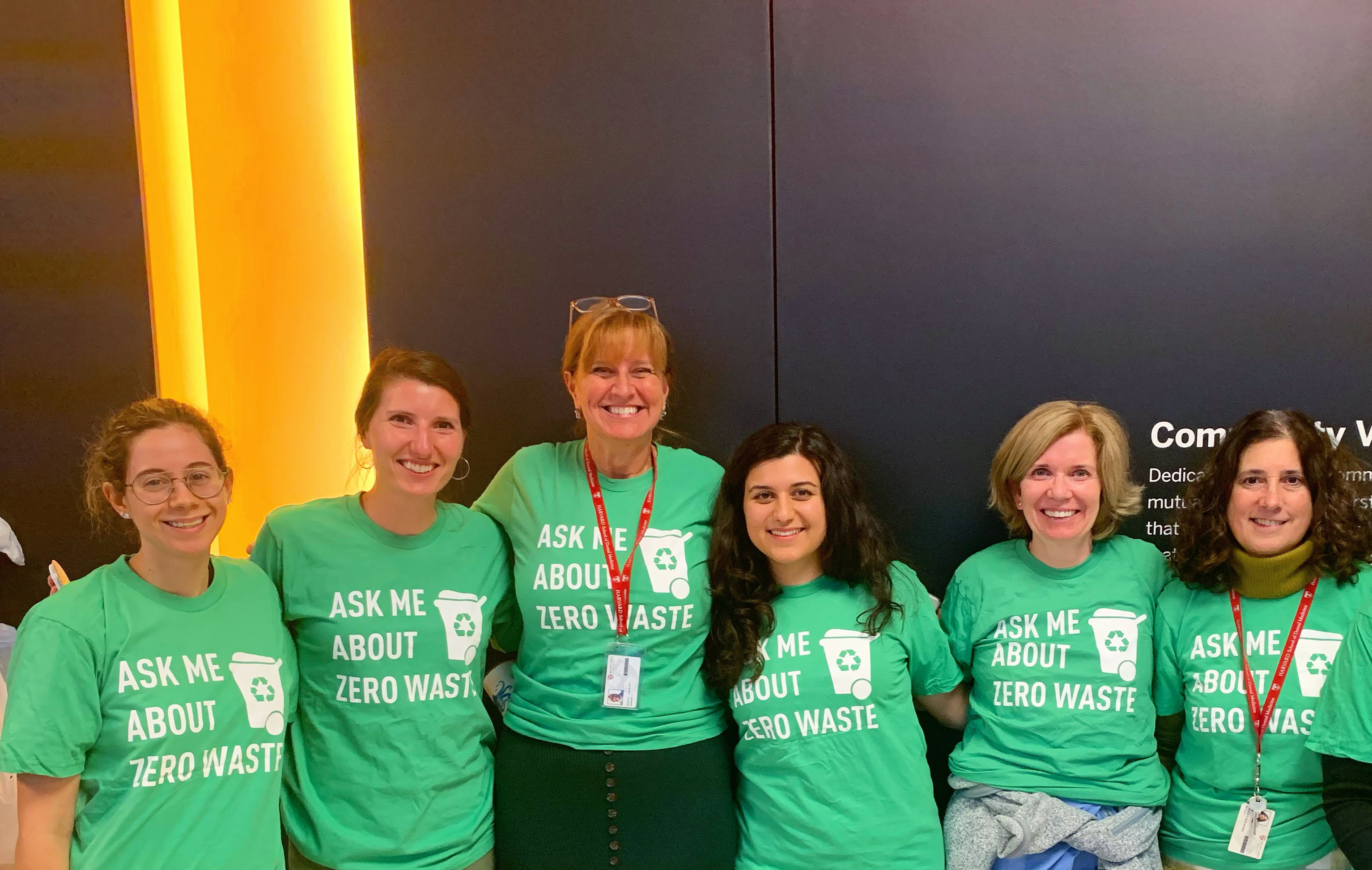Group of students, faculty and staff standing together, wearing shirts that read 