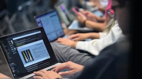 Cropped image of students typing on laptops.