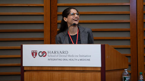 Dr. Shenam Ticku, HSDM faculty member, speaking at a podium 
