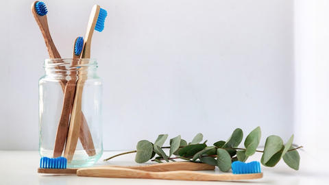 wooden recycled toothbrushes in a jar and one displayed in front of jar