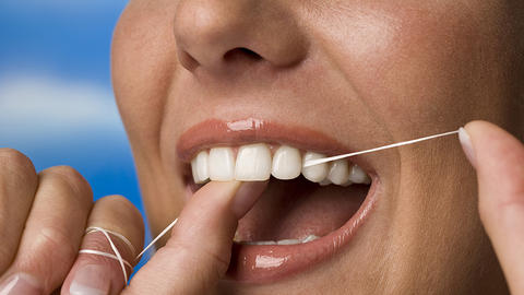 close up of a person flossing their teeth
