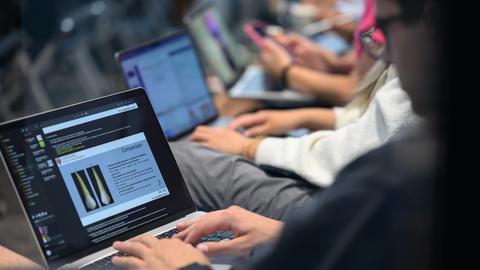 Dental students using laptops during a classroom session reviewing dental imaging and educational materials.