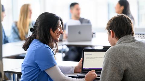 two students looking at a laptop