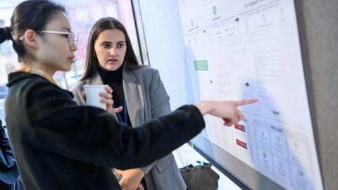 two woman in front of a poster