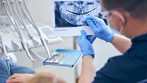 Surgeon with female discussing her jaw x-ray