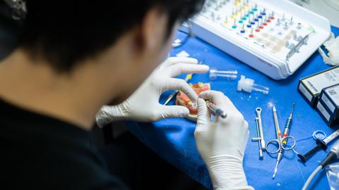 student working on a dental model