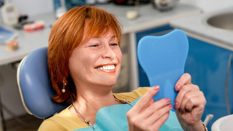 woman smiling looking into a mirror