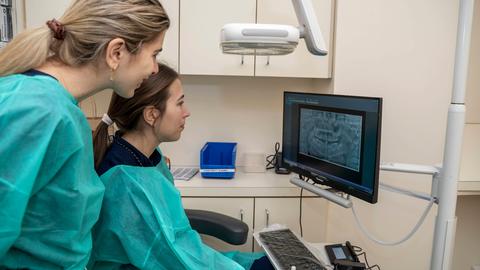 two clinicians looking at a computer screen