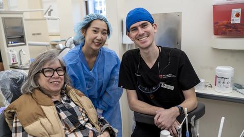 Vet sitting in dental chair with two dental students