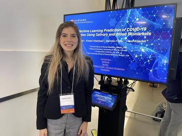 A person standing in front of their research project 