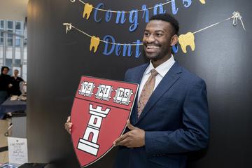 Student holding a HSDM shield cutout