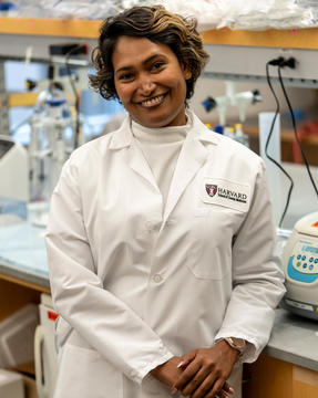 Dr. Silva in a white coat leaning on a lab bench