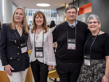 Four conference attendees pose together during a networking event.