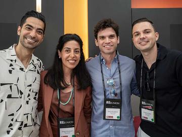 Four attendees posing together at a symposium reception.