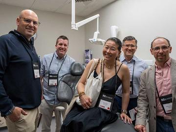 A small group of attendees standing together in a clinical teaching space.