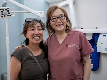 Two individuals standing together in a clinical setting.