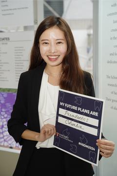 Student holding a blue sign