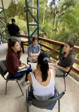 students sitting on chairs in a circle outdoors