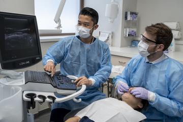 Two people working with a patient
