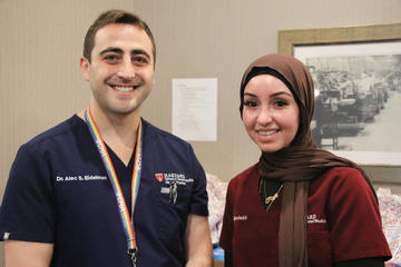 Two people standing together wearing dental scrubs