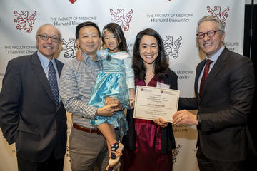 Tien Jiang holding certificate with deans and family