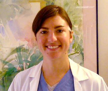 dentist in scrubs and white coat