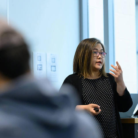 Instructor teaching in front of a whiteboard. 