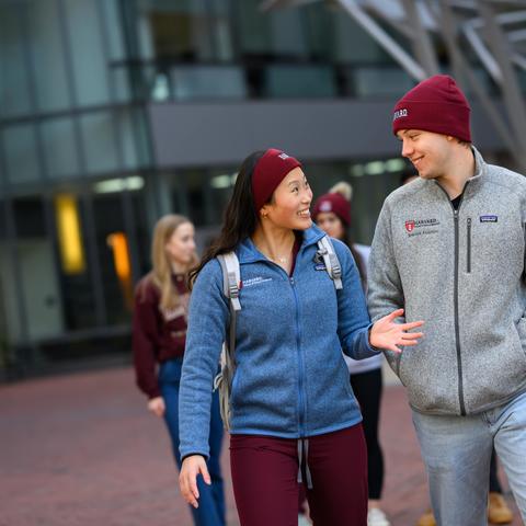 A group of students walking outside in front of the REB