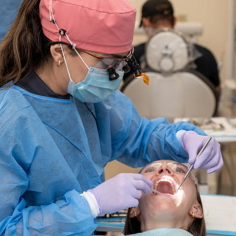 Dental student performing a oral diagnostic screening