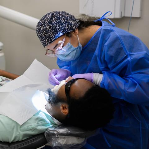 female dentist in full PPE working on a patient