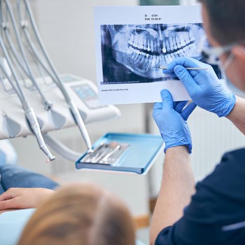 Surgeon with female discussing her jaw x-ray
