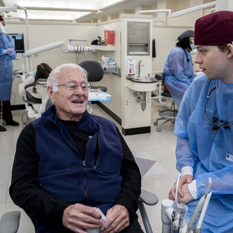 A student dentist speaks with a patient at Harvard Dental Center.