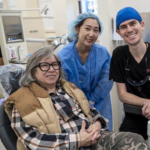 Vet sitting in dental chair with two dental students