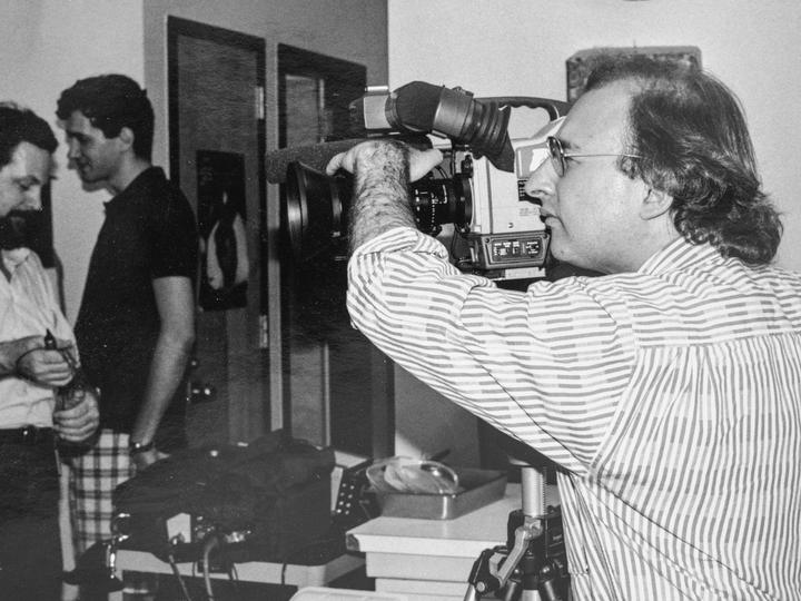 Person filming and looking through a lens 