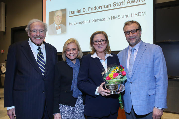 sara holding award and flowers surrounded by family
