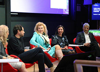 Symposium speakers participate in a discussion group.
