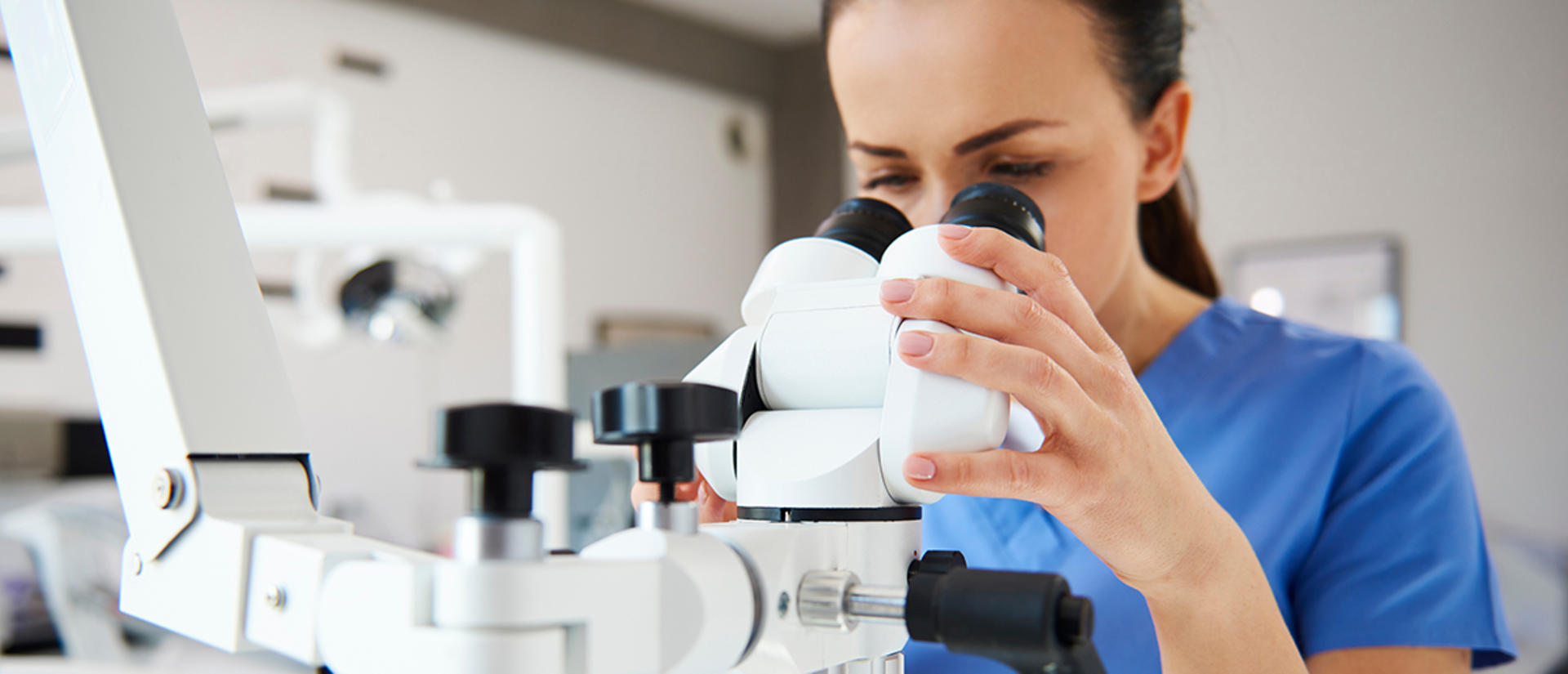 woman looking into microscope