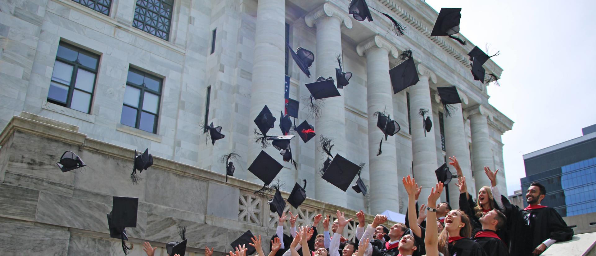 Students throwing graduation caps up in the air