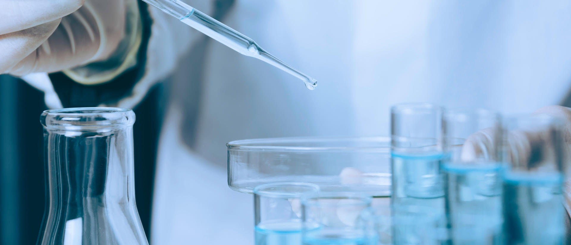Researcher with glass laboratory chemical test tubes with liquid.