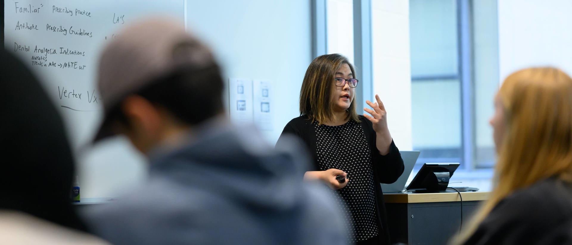 instructor in front of a white board teaching
