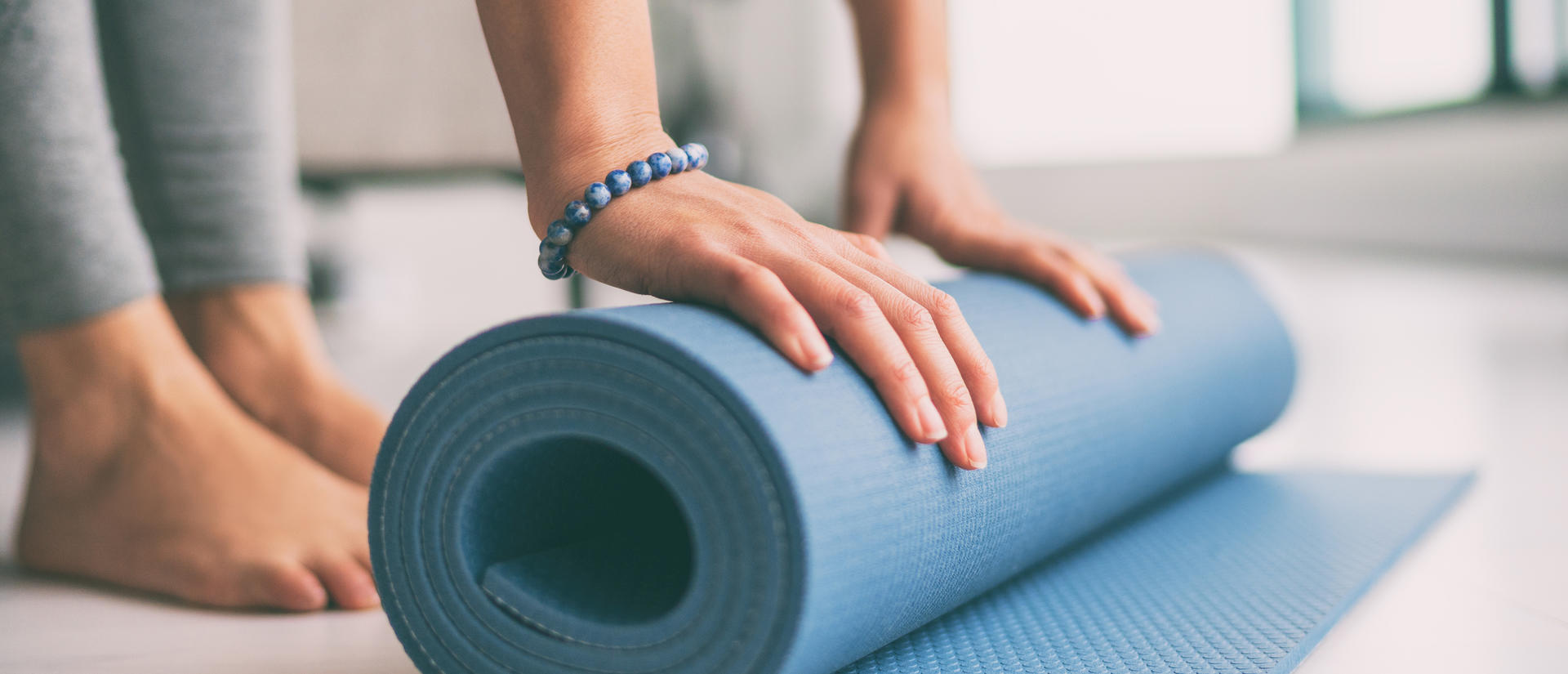 hands on a rolled yoga mat