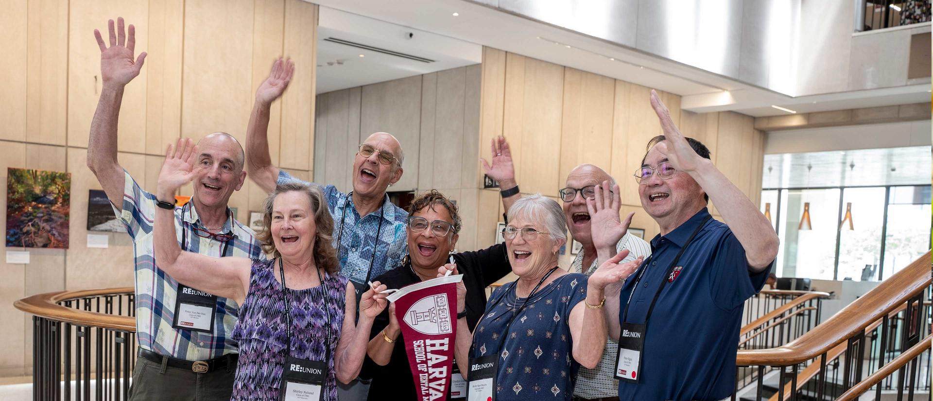 alumni waving hands