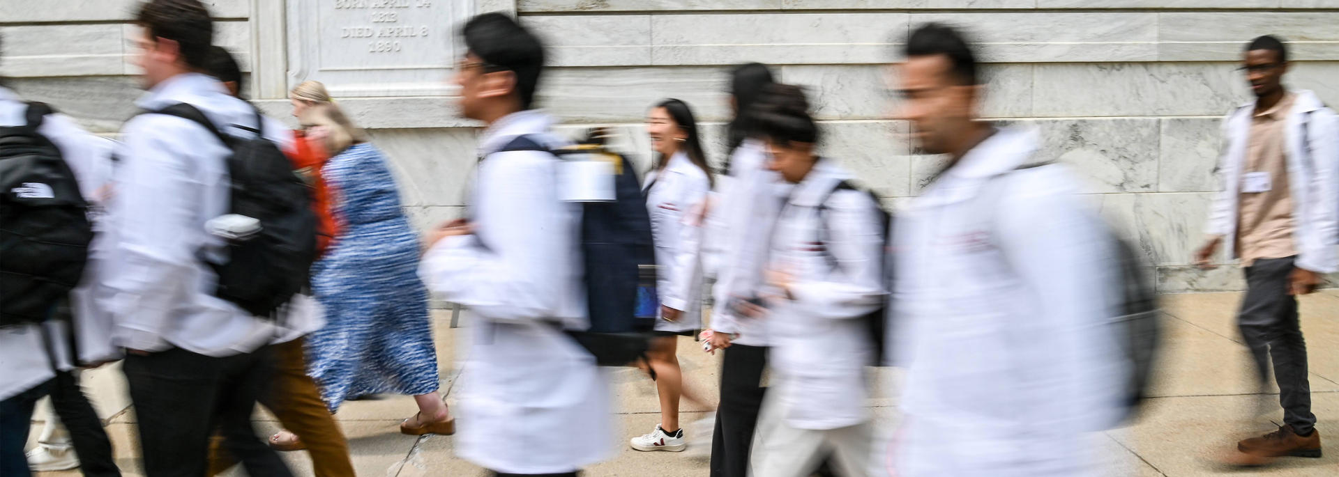 blur of students in white coats walking