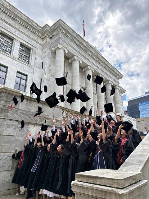 graduates throw caps in the air 