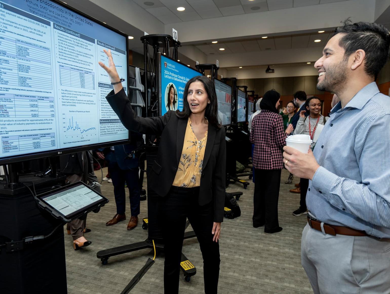 student presenting her research in front of a large screen